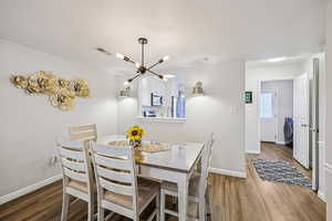 Dining space featuring wood finished floors, a textured ceiling, washer / clothes dryer, and a chandelier