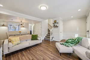 Living room featuring stairway, wood finished floors, ornamental molding, recessed lighting, and a textured ceiling