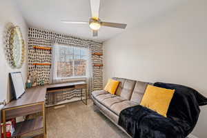 Carpeted living area featuring a textured ceiling and a ceiling fan