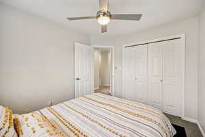 Carpeted bedroom featuring a ceiling fan and a closet