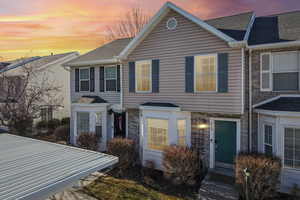 Traditional home with a shingled roof and stone siding