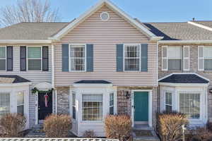 View of front of home with stone siding and a shingled roof