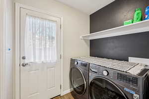 Laundry area with washing machine and dryer, wood finished floors, and a textured ceiling