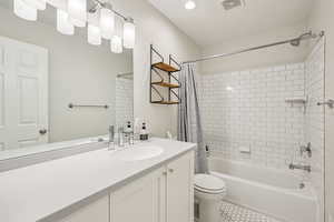 Full bath featuring vanity, shower / bath combination with curtain, light tile patterned flooring, and recessed lighting
