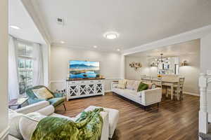 Living area featuring wood finished floors, a chandelier, recessed lighting, crown molding, and a textured ceiling