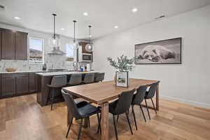 Dining space with light wood-style floors and recessed lighting