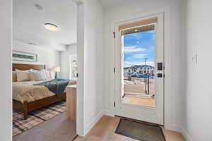 Doorway to outside with wood finished floors and baseboards