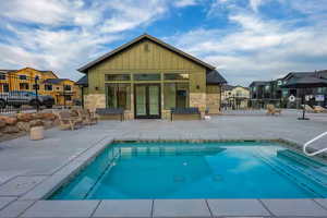 Community pool with a residential view, a patio area, a jacuzzi, and french doors