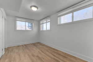 Unfurnished bedroom with a textured ceiling, light wood-style floors, and a closet