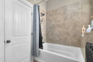 Bathroom featuring shower / bathtub combination with curtain