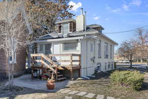 Rear view of property with a chimney, roof with shingles, and a patio