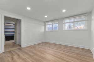 Empty room featuring light wood-type flooring and recessed lighting