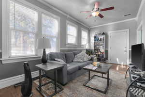 Living area featuring wood finished floors, crown molding, a ceiling fan, and a textured ceiling