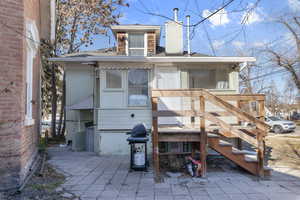 Rear view of house with a chimney and roof with shingles