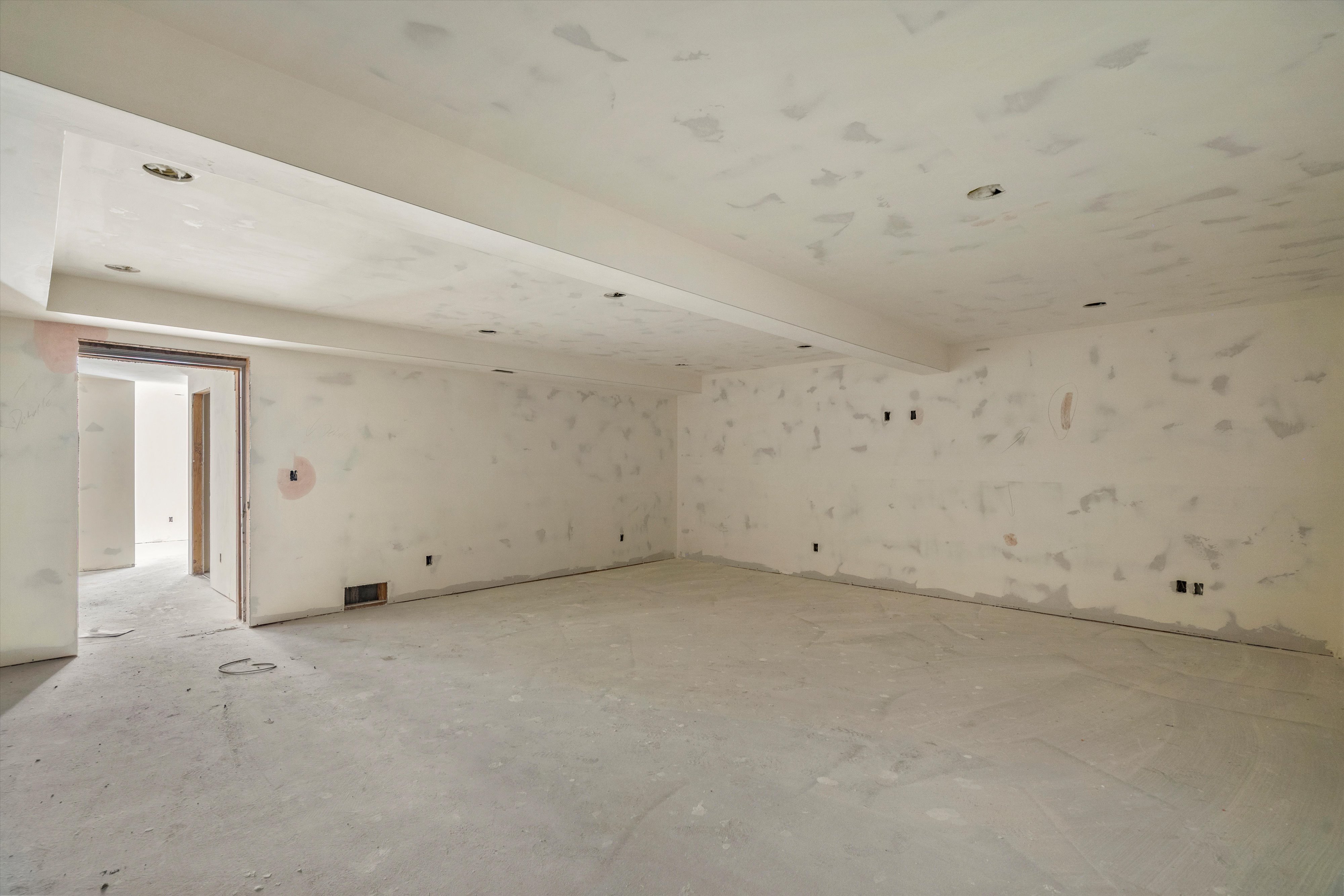 Spacious unfinished interior area with a concrete floor, recessed lighting, and multiple wall outlets