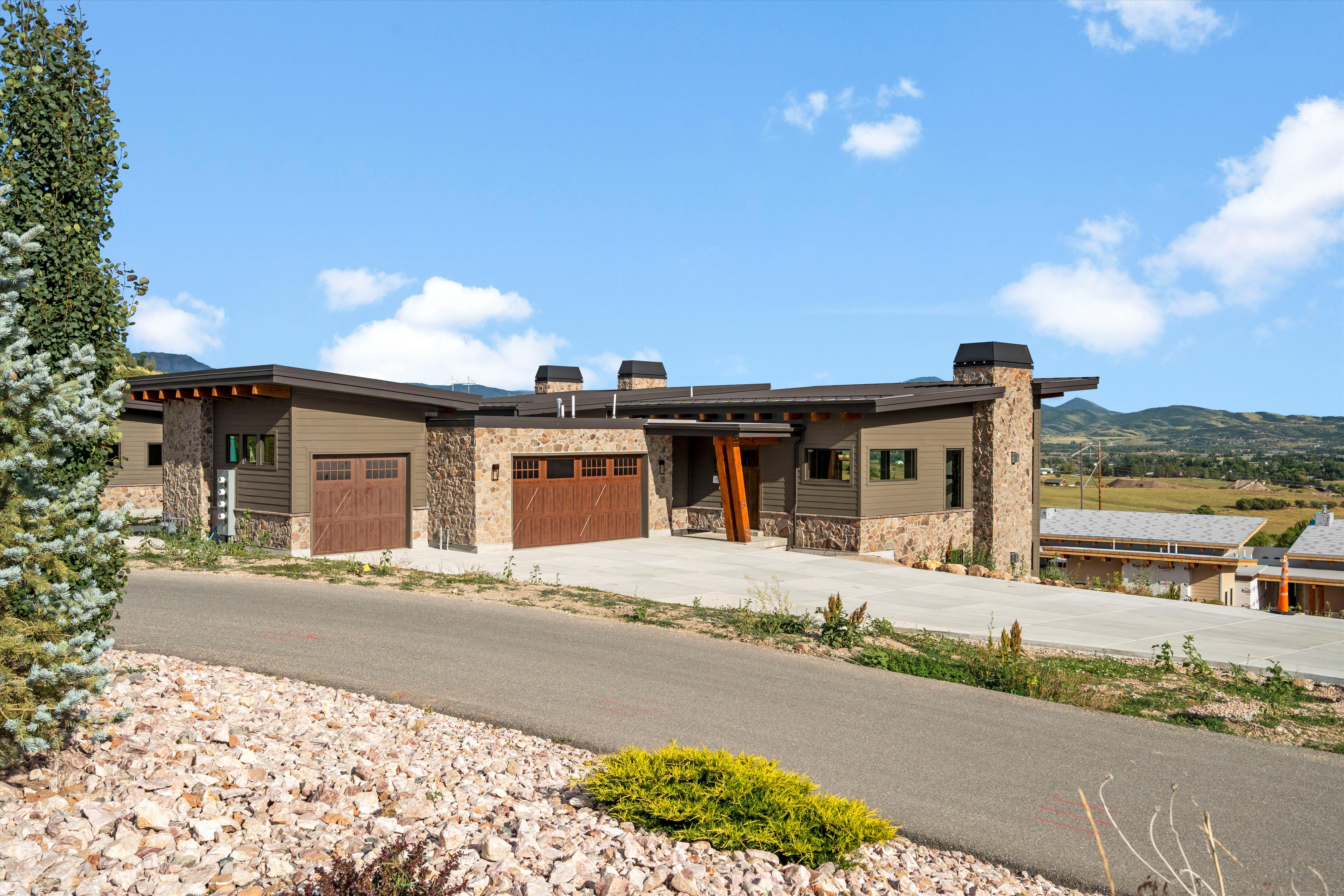 Contemporary single-story residence showcasing a multi-textured facade with stone accents and horizontal siding