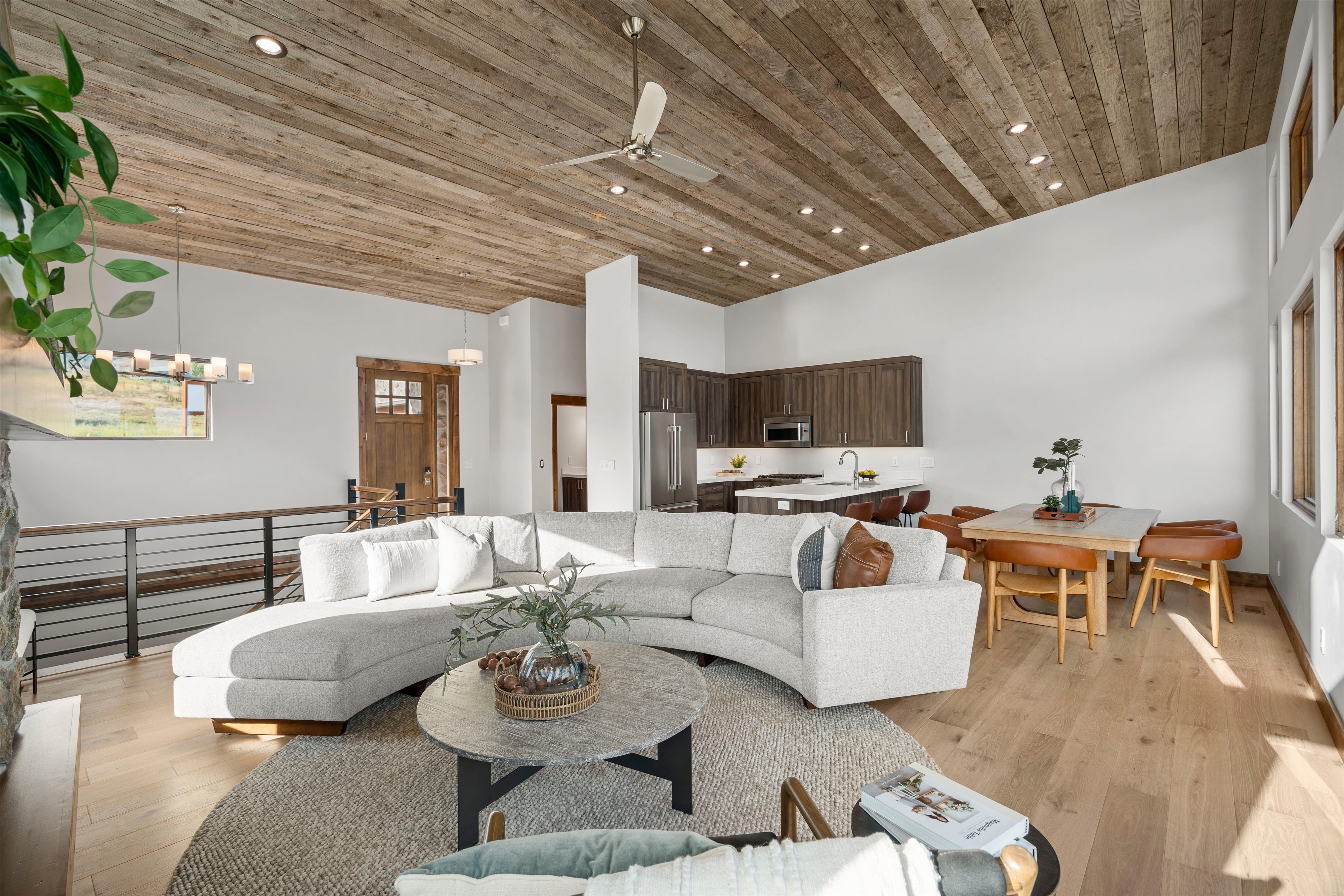 Open-concept living space featuring wood-finish flooring, a vaulted planked wood-finish ceiling, and ample natural light from multiple windows