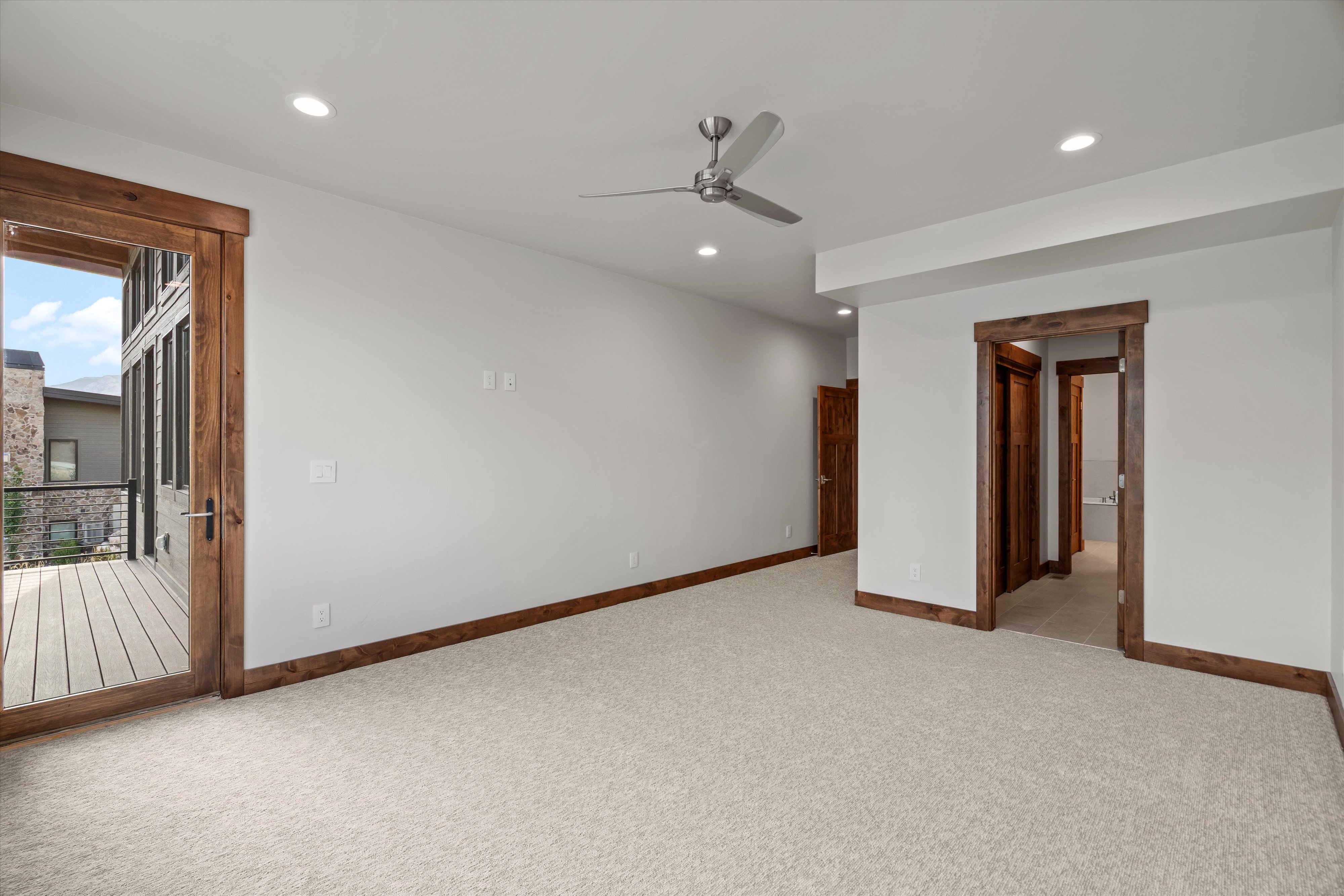 Spacious room featuring light-colored carpeting, recessed lighting, and a ceiling fan