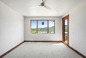 Spacious room featuring broad picture windows, a wood-framed glass door, and recessed lighting