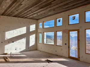 Unfurnished living room with wooden ceiling and a towering ceiling