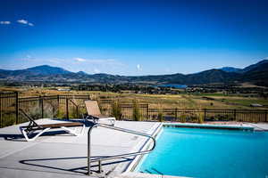 View of pool with a mountain view and a patio area