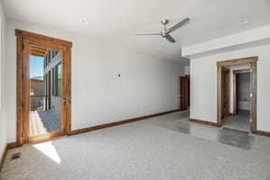 Spacious room with light-colored carpeting, recessed lighting, and a contemporary ceiling fan