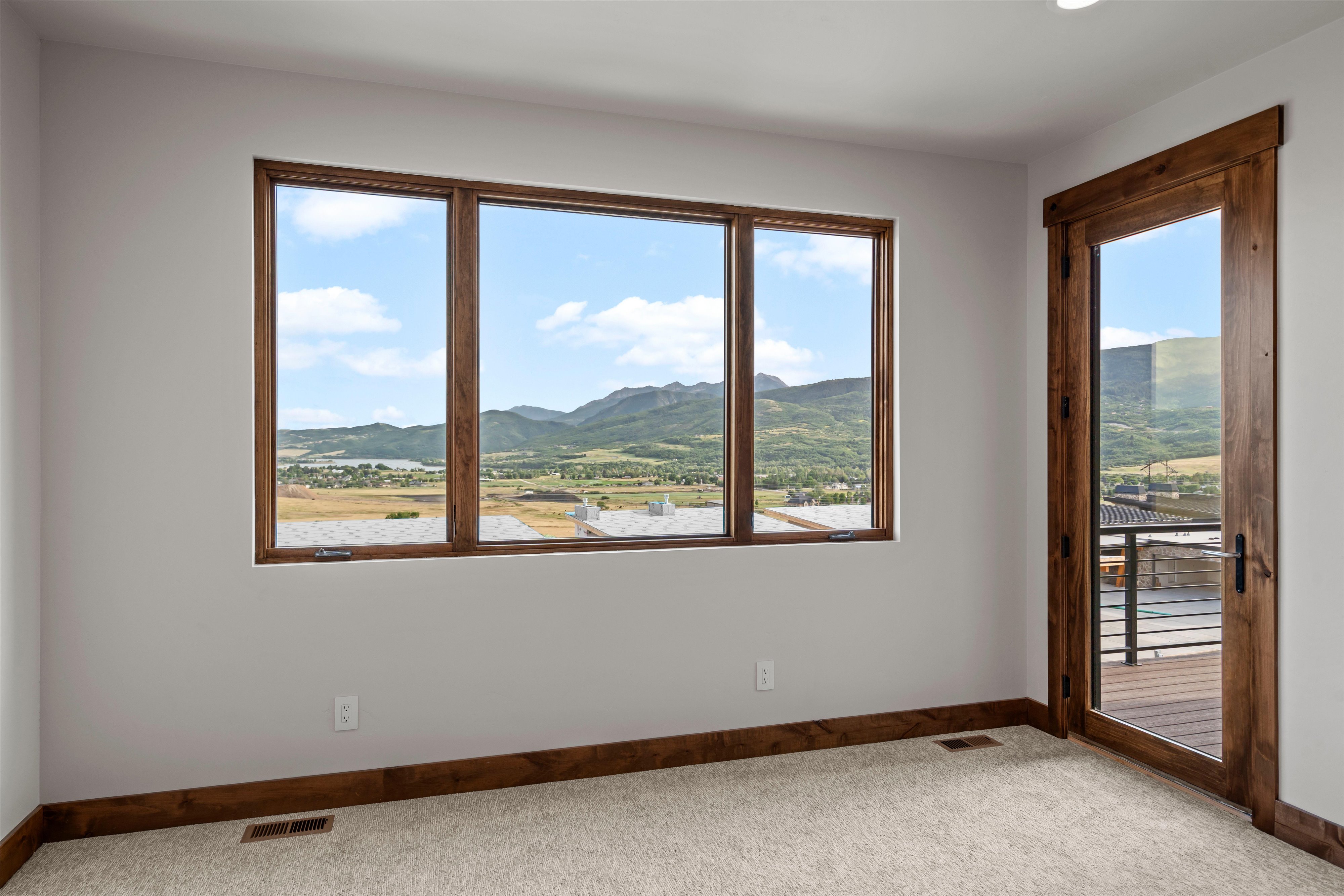 Bright room featuring a multi-pane window and a glass-paneled door with wood-finish frames
