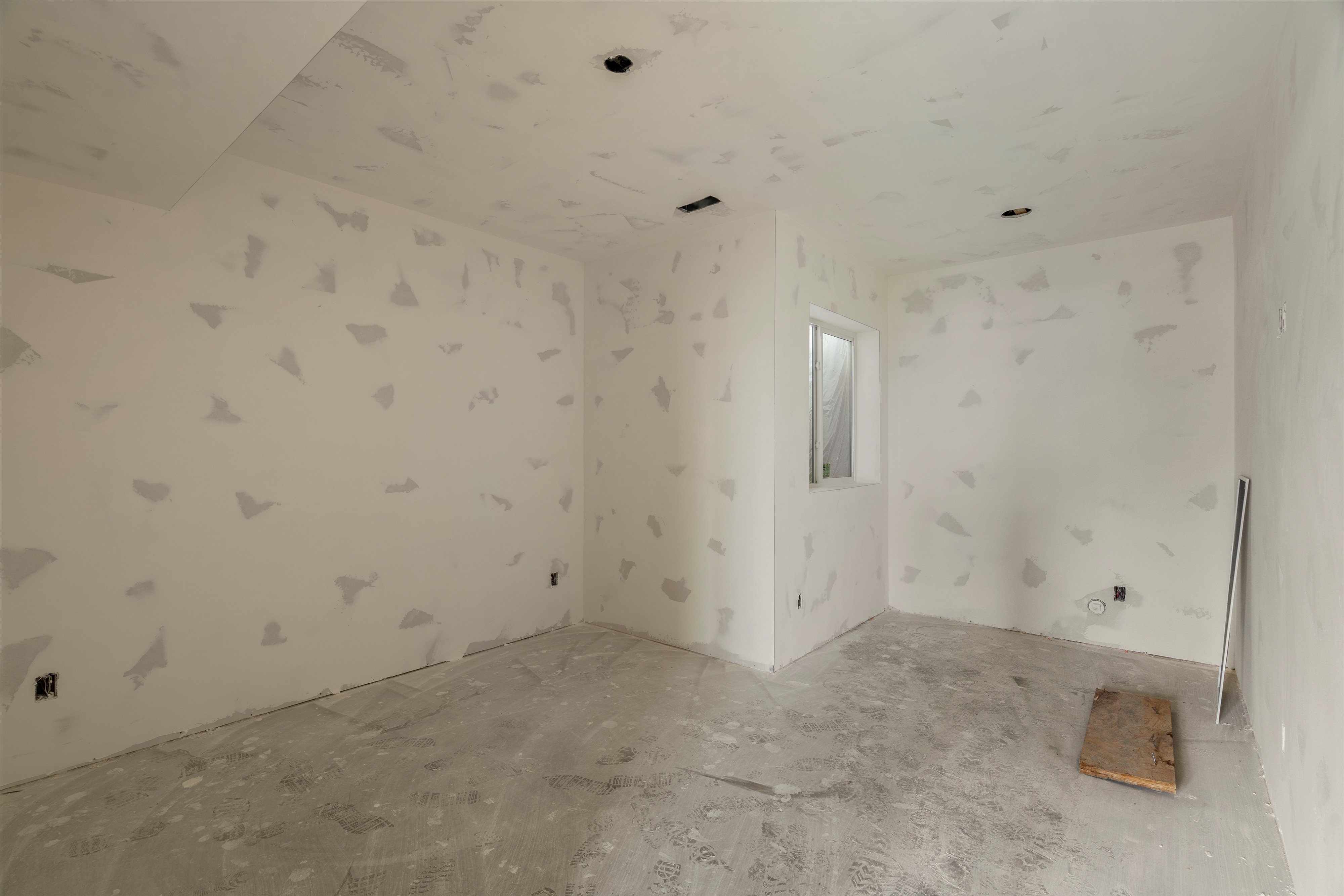 Unfinished room with natural light, featuring a single window, recessed lighting rough-ins, and a concrete floor