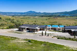 Modern residential development featuring stone and wood-paneled exteriors, dark metal roofs, and attached garages