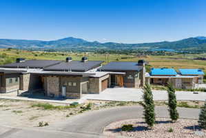 Contemporary exterior featuring a metal roof, stone veneer, and stucco siding