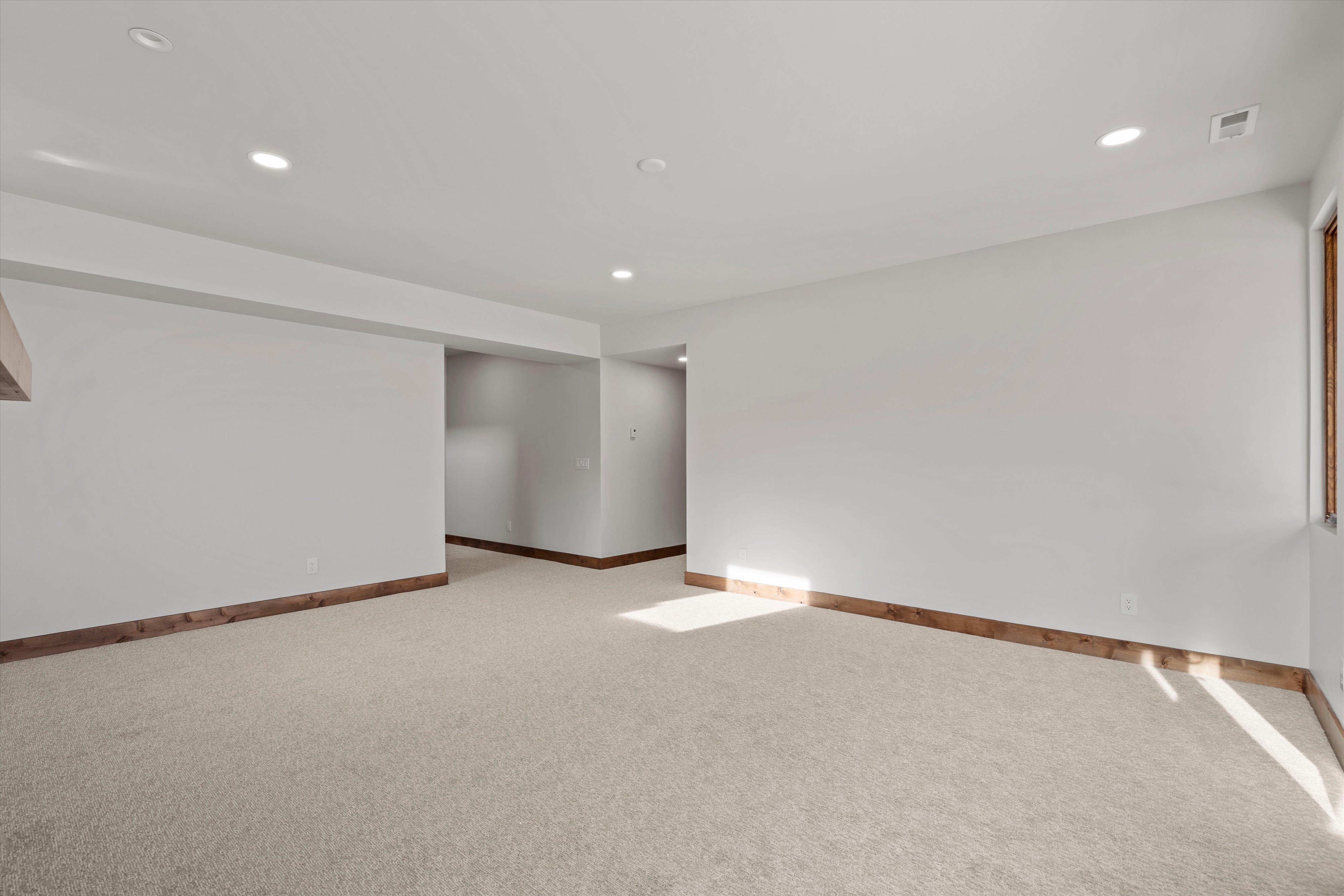 Carpeted room featuring recessed lighting, white walls, and wood-finish baseboards