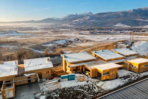Snowy aerial view featuring a mountain view and a residential view