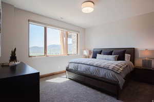 Carpeted bedroom featuring baseboards and a mountain view