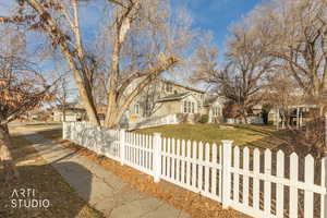 Traditional-style house with a fenced front yard and a residential view