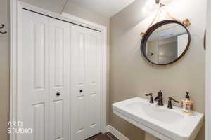 Bathroom featuring a closet and a sink