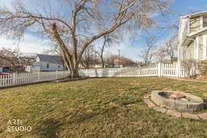 Fenced backyard with an outdoor fire pit