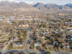 Aerial view of property and surrounding area with nearby suburban area and mountains