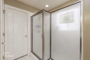 Bathroom featuring a stall shower and recessed lighting