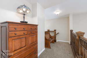 Corridor with light carpet and an upstairs landing