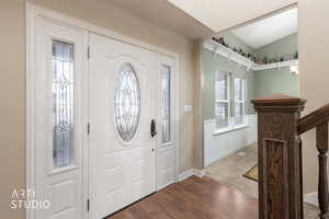 Entryway featuring dark wood-style flooring and vaulted ceiling