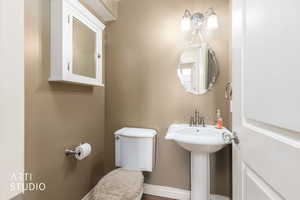 Half bathroom featuring toilet and baseboards