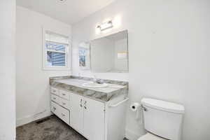 Bathroom with vanity and dark colored carpet