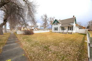 View of front of property featuring a chimney, a residential view, and a shingled roof