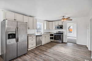 Kitchen with stainless steel appliances, light countertops, healthy amount of natural light, and dark wood finished floors