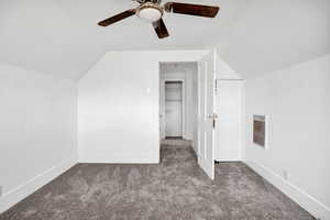 Additional living space featuring vaulted ceiling, carpet flooring, and a ceiling fan