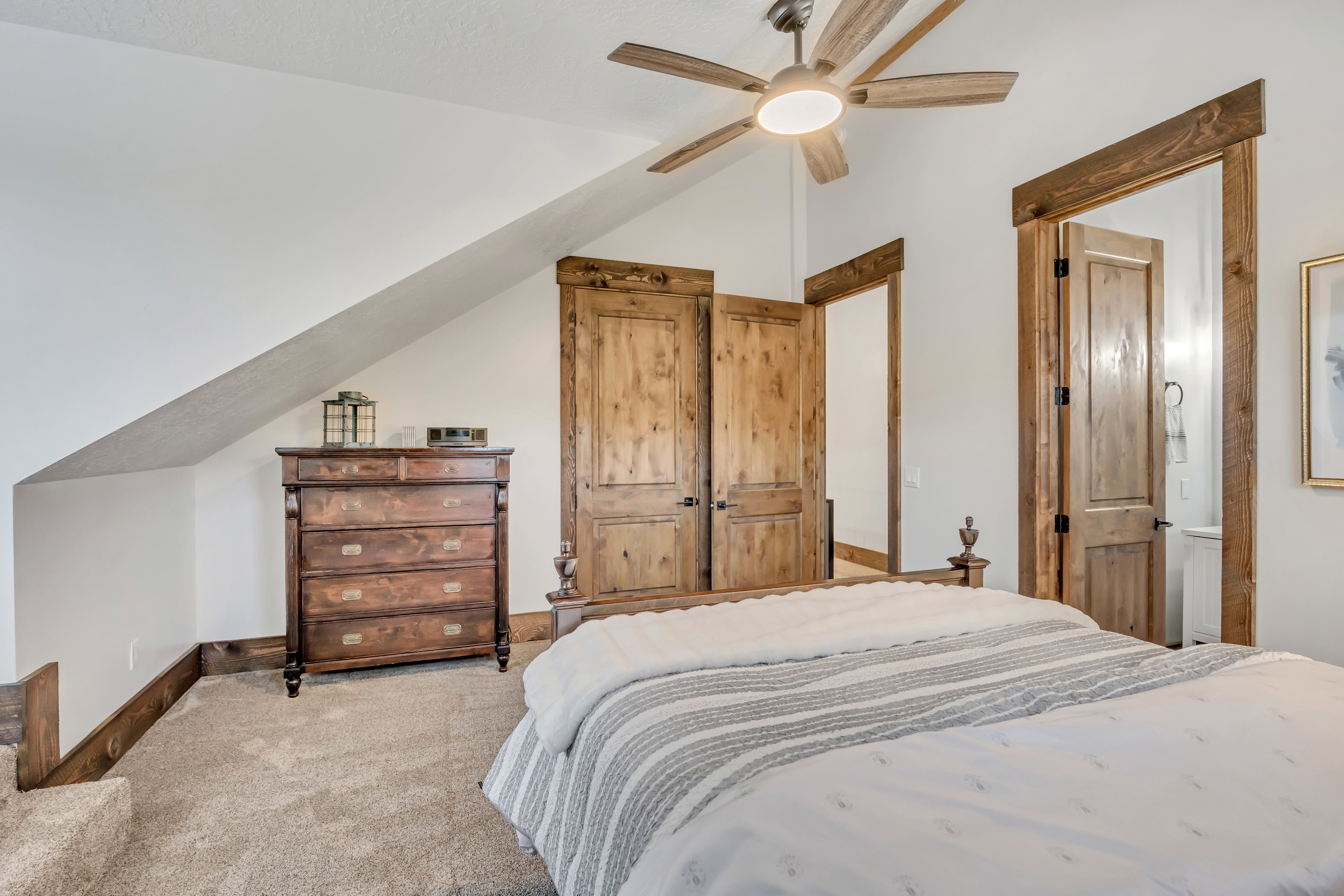 Carpeted bedroom featuring vaulted ceiling and ceiling fan