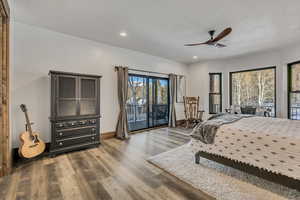 Bedroom with wood finished floors, access to exterior, a ceiling fan, recessed lighting, and a textured ceiling