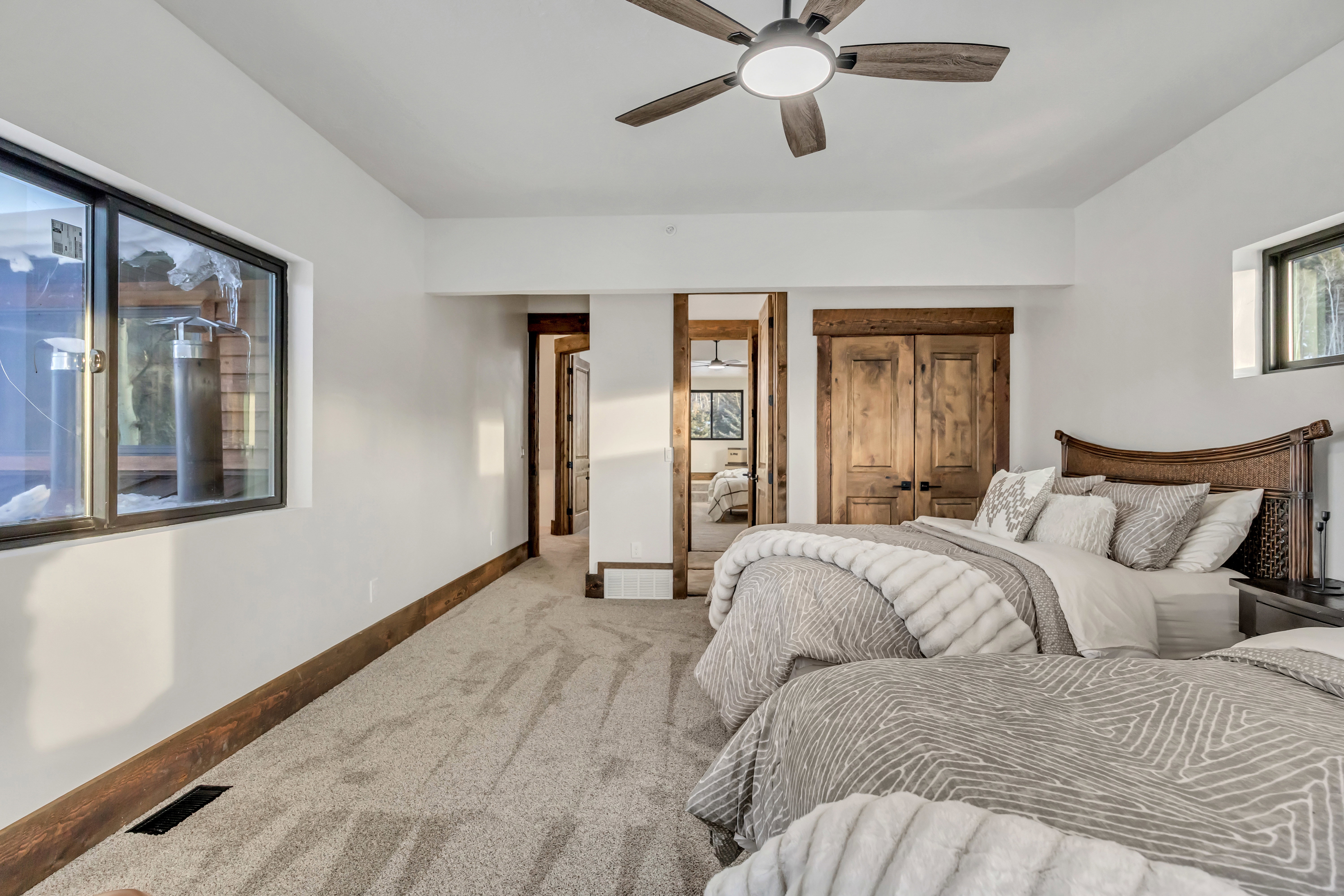 Bedroom with carpet flooring, connected bathroom, and a ceiling fan