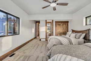 Bedroom with carpet flooring, connected bathroom, and a ceiling fan