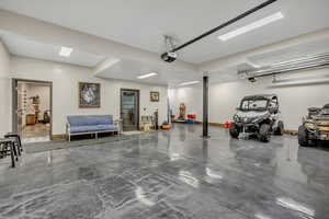 Garage featuring baseboards and a garage door opener